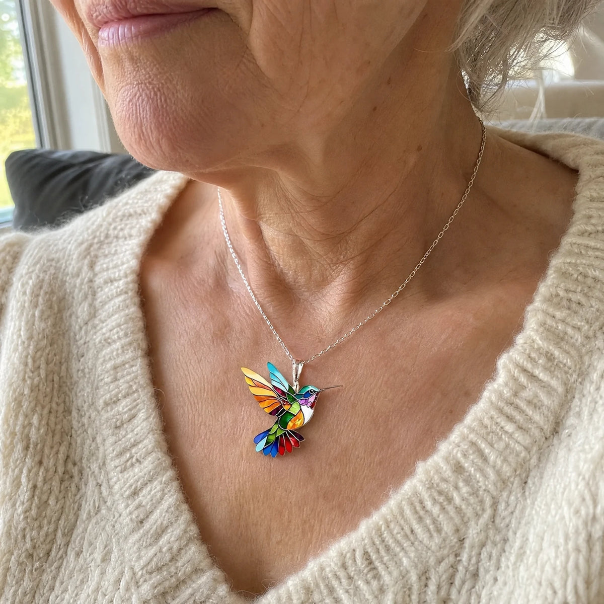Hummingbird necklace worn over a cream jumper